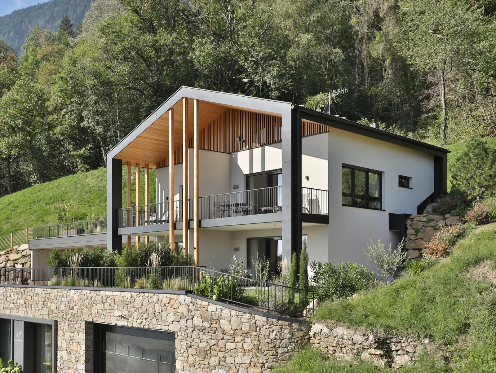 Realisiertes Bauvision Projekt am Hang in Marling mit Holz- und Natursteinfassade